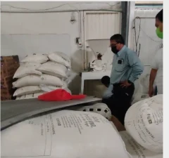 Técnicos inspeccionando un almacén de sacos de alimento